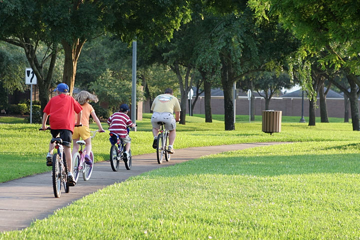 family cycling in a Sugar Land, Texas park